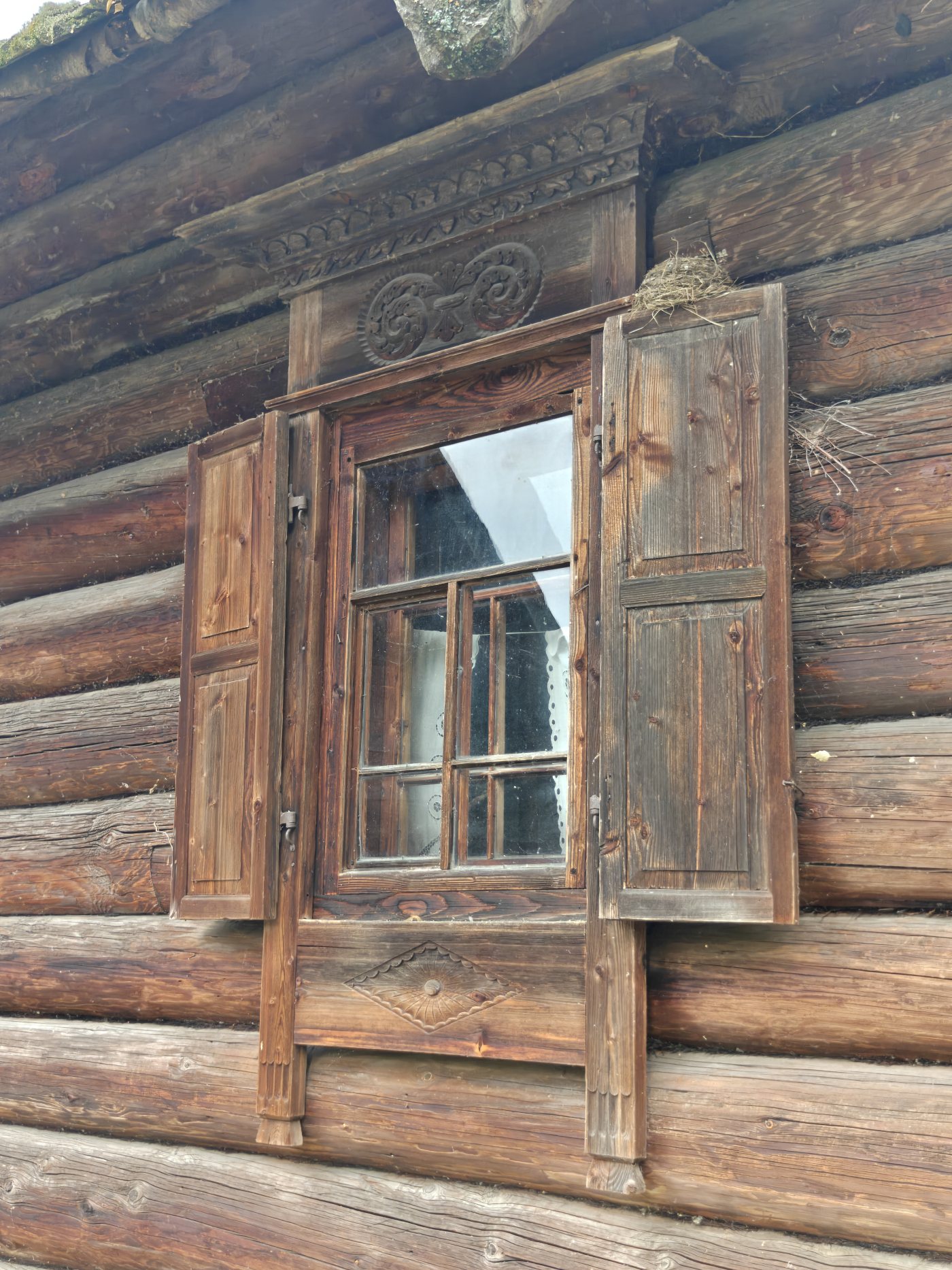 Тёмный наличник с распахнутыми ставнями
